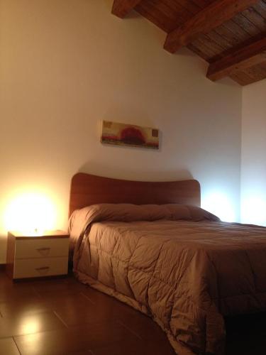 1 dormitorio con 1 cama y una pintura en la pared en Casa Vacanze Agriturismo Cilone, en Ragusa