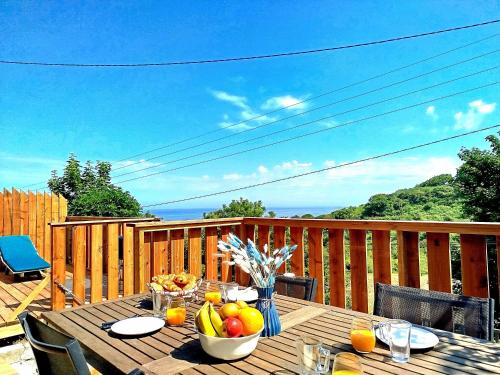 - une table en bois avec un bol de fruits sur une terrasse dans l'établissement Le 42 - Second Souffle - Bretteville, à Bretteville