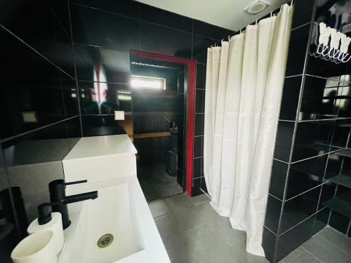a bathroom with a sink and a toilet and a shower at Cozy Family House with Sauna & Garden in Kärdla