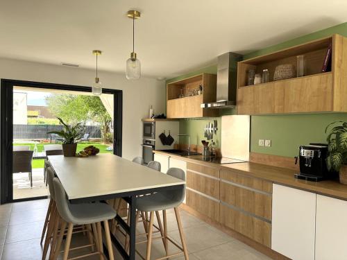 une cuisine avec une table et des chaises dans une cuisine dans l'établissement Villa moderne 120m2 avec bain nordique, à Charmes-sur-Rhône