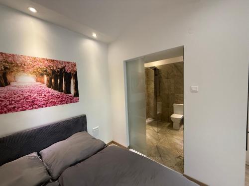 a bedroom with a large painting on the wall at Lilly apartments in Bratislava