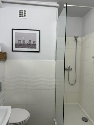 a bathroom with a glass shower and a toilet at Panorama Bałtyku in Sopot