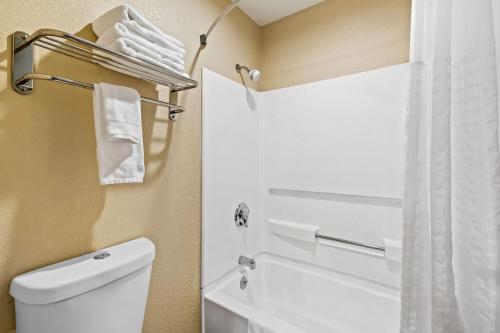 a bathroom with a toilet and a shower with towels at Days Inn by Wyndham Black River Falls - Access to ATV Trail in Black River Falls