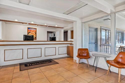 a lobby with a bar and two chairs at Travelodge by Wyndham Page, View of Lake Powell in Page