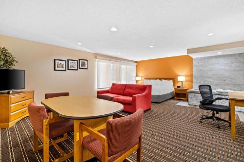 a hotel room with a couch and a table and a bed at Days Inn by Wyndham Black River Falls - Access to ATV Trail in Black River Falls
