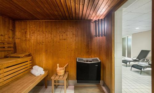 a room with a wood paneled wall with a trash can at Wyndham Garden Potsdam in Potsdam