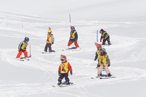 a group of children skiing down a snow covered slope at Ski- und Wander Appartements Schiffer in Innerkrems