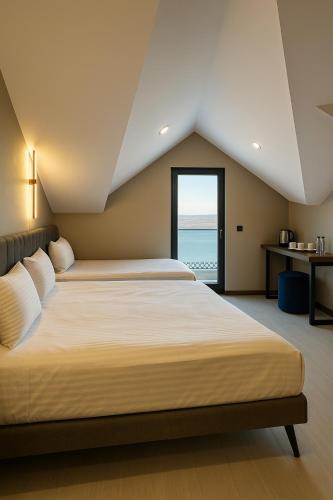 a bedroom with two beds and a view of the ocean at Loft Park Hotel - Airport 10 Minute in Arnavutköy