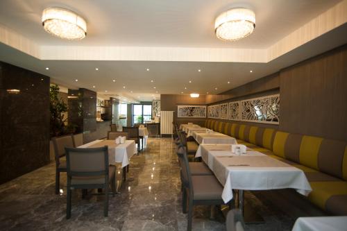 a dining room with white tables and chairs at Yeni Bahar Otel in Ankara