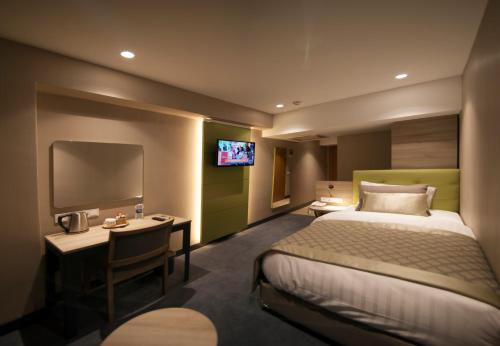 a hotel room with a bed and a desk and a tv at Yeni Bahar Otel in Ankara