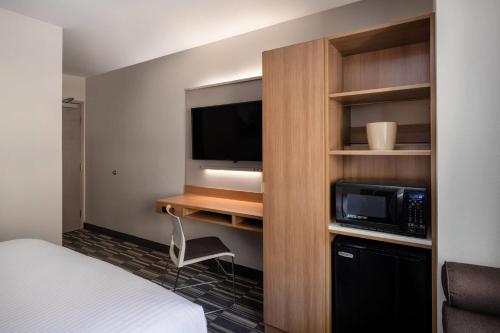 a hotel room with a bed and a microwave and a tv at Microtel Inn & Suites by Wyndham Georgetown Lake in Georgetown