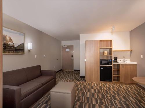 a living room with a couch and a kitchen at Microtel Inn & Suites by Wyndham Georgetown Lake in Georgetown