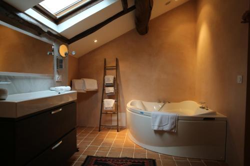 a bathroom with a tub and a sink and a skylight at Chateau de la Rode in Aumessas