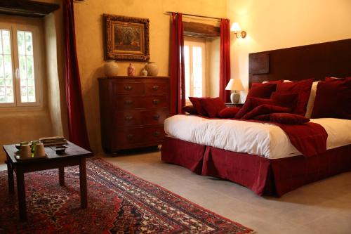 a bedroom with a large bed with red pillows at Chateau de la Rode in Aumessas