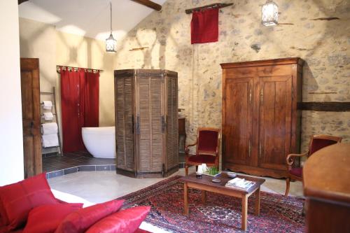 een woonkamer met een bad, een bank en een tafel bij Chateau de la Rode in Aumessas