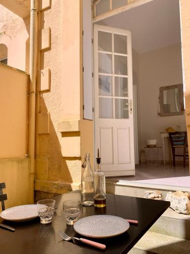 - une table avec deux assiettes et une bouteille dans l'établissement Bel appartement, 20m de la plage - Cour privée, à Les Sables-dʼOlonne