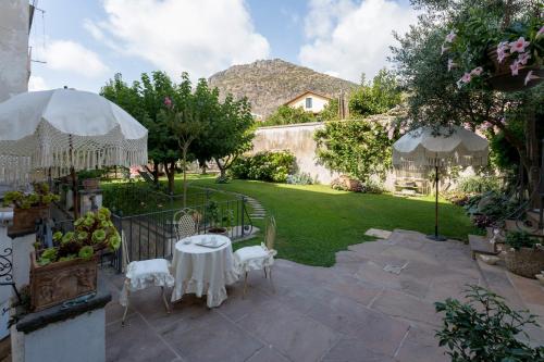 a patio with a table and chairs in a yard at Palazzo Cacace Relais in Meta