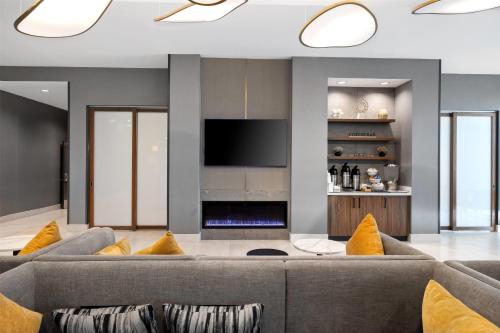 a living room with a couch and a television at La Quinta Inn & Suites by Wyndham La Habra in La Habra