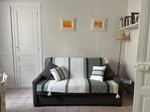 - un salon avec un canapé et des oreillers dans l'établissement Bel appartement, 20m de la plage - Cour privée, à Les Sables-dʼOlonne