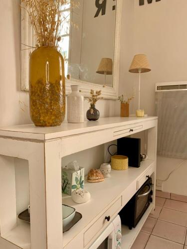 un comptoir de cuisine blanc avec un vase dessus dans l'établissement Bel appartement, 20m de la plage - Cour privée, à Les Sables-dʼOlonne