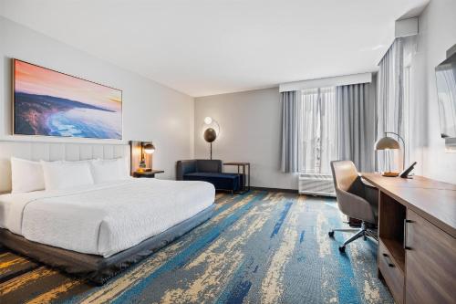 a hotel room with a bed and a desk at La Quinta Inn & Suites by Wyndham La Habra in La Habra