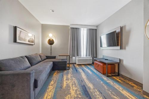 a living room with a couch and a table at La Quinta Inn & Suites by Wyndham La Habra in La Habra