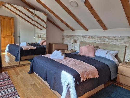 a bedroom with two beds and a mirror at Akvamarin Stone House in Medulin