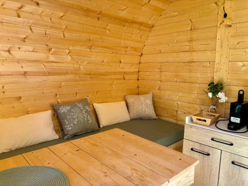 a small room with a couch in a wooden cabin at Camping Les Voiles Sur Grosne in Savigny-sur-Grosne