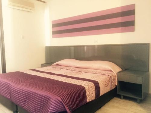 Un dormitorio con una cama y un cuadro en la pared. en Agrino Hotel Apartments, en Ayia Napa