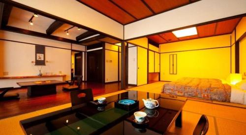 a large room with a bed and a living room at Kannawa Onsen Hotel Sansuikan in Beppu