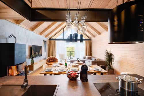 a kitchen with a table and a living room at Chalet Wellness TRI VODY Demänovská Dolina in Liptovský Mikuláš