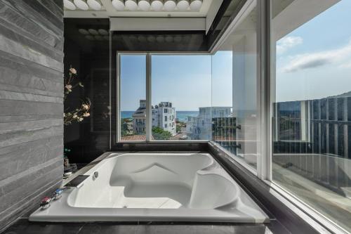 a bath tub in a room with a large window at 白水木民宿 in Eluan