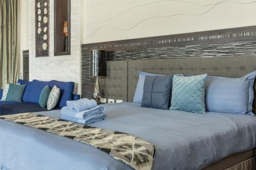 a bedroom with a large bed with blue pillows at 白水木民宿 in Eluan
