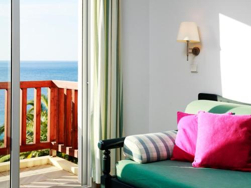 a room with a couch and a view of the ocean at Hapimag Resort Damnoni in Damnoni