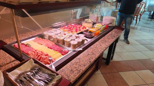 a buffet line with meats and other food on a counter at Hotel Capri in Grado