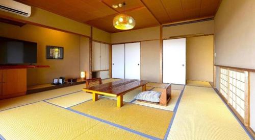 a living room with a wooden table in a room at Yukemuri no sato azumaya in Beppu