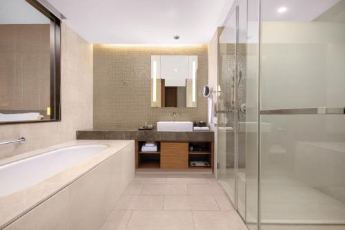 a bathroom with a tub and a sink at Ascott Raffles City Chengdu in Chengdu