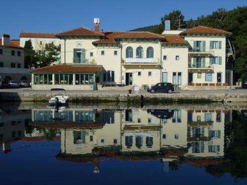 a group of buildings next to a body of water at Hotel Televrin in Nerezine