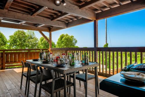 eine Holzterrasse mit einem Tisch und Stühlen darauf in der Unterkunft オーシャンビュー BBQ可 最大8名 自然を満喫できる宿 Maru in Motobu