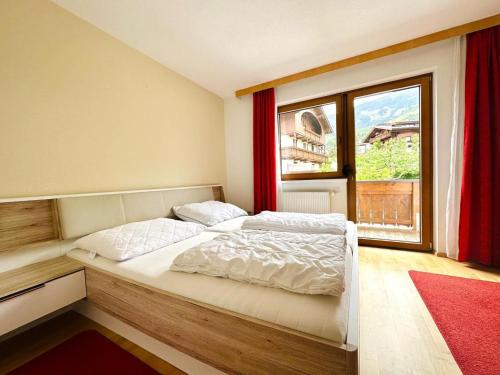 a bedroom with a bed and a large window at Apartment in Fügen near Ski Lift in Fügen