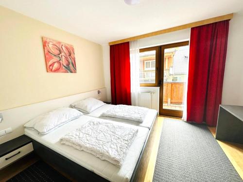 a bedroom with a large bed with red curtains at Apartment in Fügen near Ski Lift in Fügen
