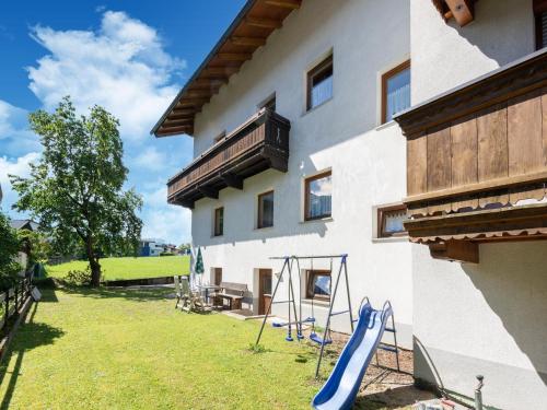 a house with a slide in a yard next to a building at Apartment in Fügen near Ski Lift in Fügen