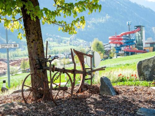 a metal bench sitting next to a tree at Apartment in Fügen near Ski Lift in Fügen