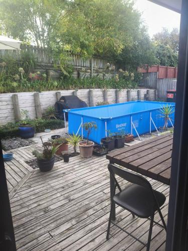 a patio with a blue table and a chair at House On The Hill in Hamilton