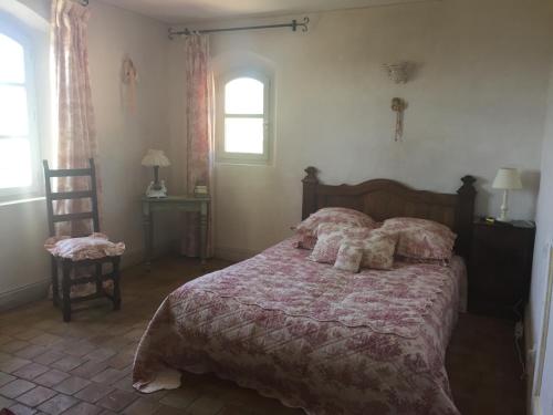 コティニャックにあるLa bastide des angesのベッドルーム1室(ベッド1台、窓、椅子付)