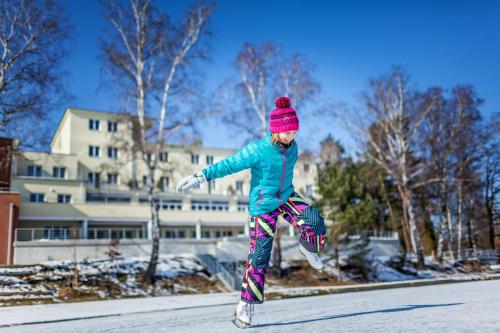 a young girl is jumping in the street at Hotel Port Doksy in Staré Splavy