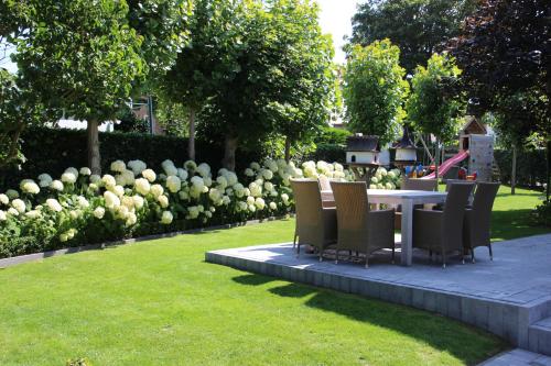 un tavolo e sedie in un parco con un giardino di Villa Dageraad a De Panne