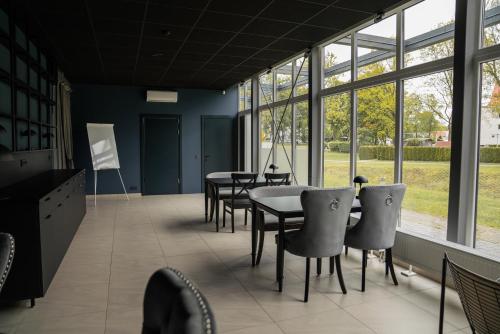 a conference room with tables and chairs and windows at Birštono Banginukas poilsio namai in Birštonas