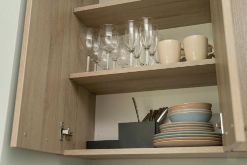 a cabinet with wine glasses and plates on it at Birštono Banginukas poilsio namai in Birštonas
