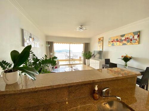 une cuisine avec un évier et un salon dans l'établissement Le Panomagique, à Villefranche-sur-Mer